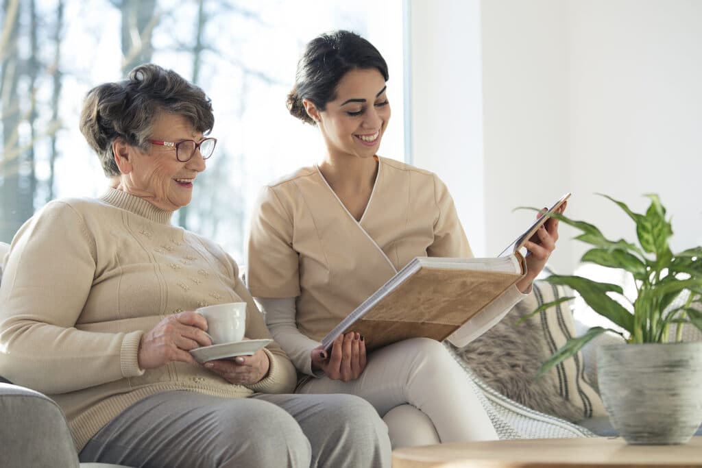 Caregiver supporting senior woman with memory activities at home